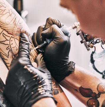 Tattoo Artist making a tattoo on a shoulder