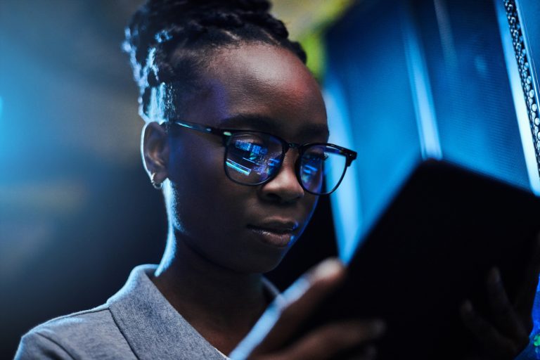 Shot of a young female engineer using a digital tablet while working in a server room