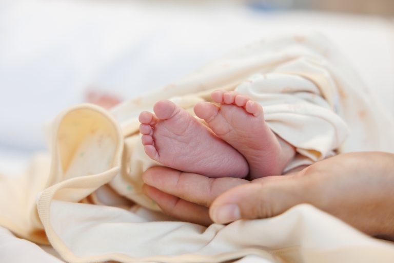 newborn baby feet on male hands. concept : Premature or preterm baby in hospital. relationship between father and baby.