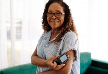 Woman checking her blood sugar levels with continuous glucose monitoring