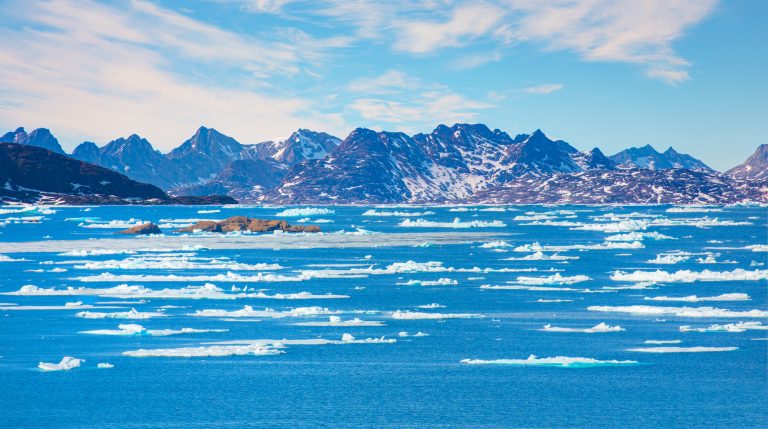 Melting icebergs by the coast of Greenland, on a beautiful summer day - Melting of a iceberg and pouring water into the sea - Greenland