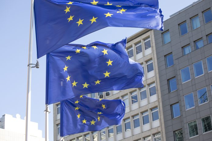 EU flags outside a modern office building in Brussels