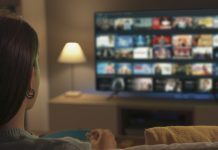 Young woman watching video on demand on her TV