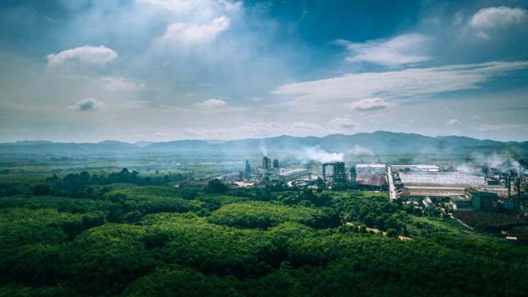 Aerial view industrial factory in the morning mist, the morning sunrises. Industrial factory and environment concept. Steam to air. Air pollution.