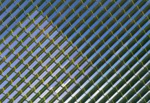 Top down view of rows of blue solar panels in a large solar power station.