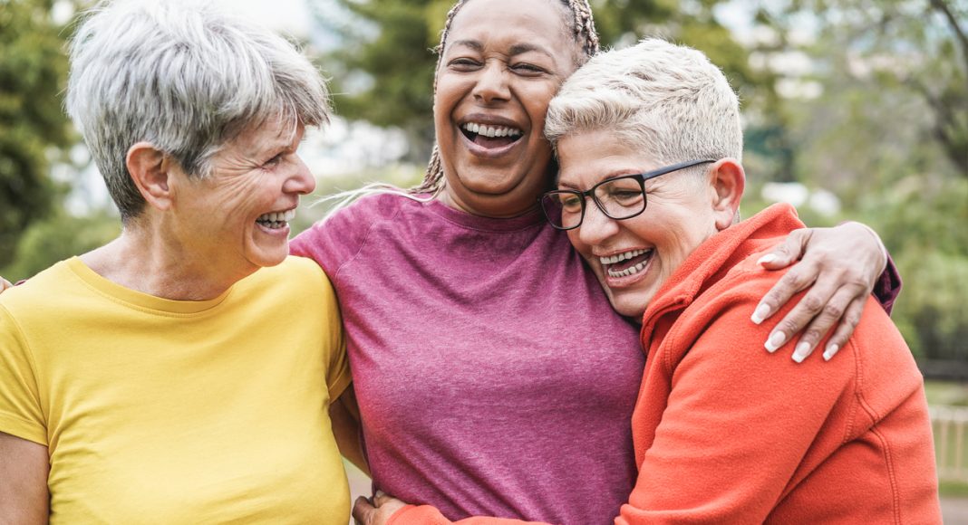 Multiracial senior women having fun together after sport workout outdoor - Main focus on african female face