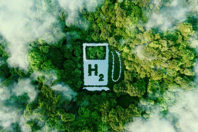 A lake in the shape of a hydrogen filling station used as a concept to illustrate the environmental friendliness of hydrogen and its potential as the fuel of the future. 3d rendering.