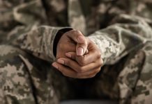 Clasped Hands Of Black Soldier Woman In Camouflage Uniform, Closeup Shot