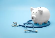 Piggy bank with stethoscope isolated on light blue background with copy space. Health care financial checkup or saving for medical insurance costs concept.