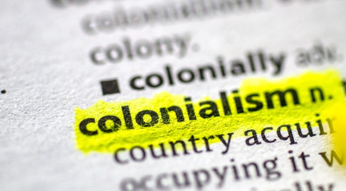 Close up photo of the word colonialism in a dictionary book