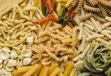 Table top view of variety of uncooked pasta. Full frame of different types of dried pasta on table.