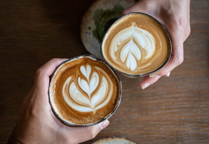 High angle view of friends meeting in cafe with a cup of hot latte coffee.