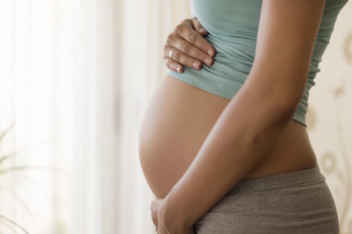 Pregnant woman embracing her belly