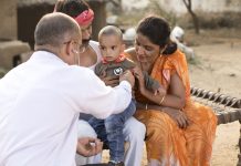 Pediatrician doctor examining ill boy at village