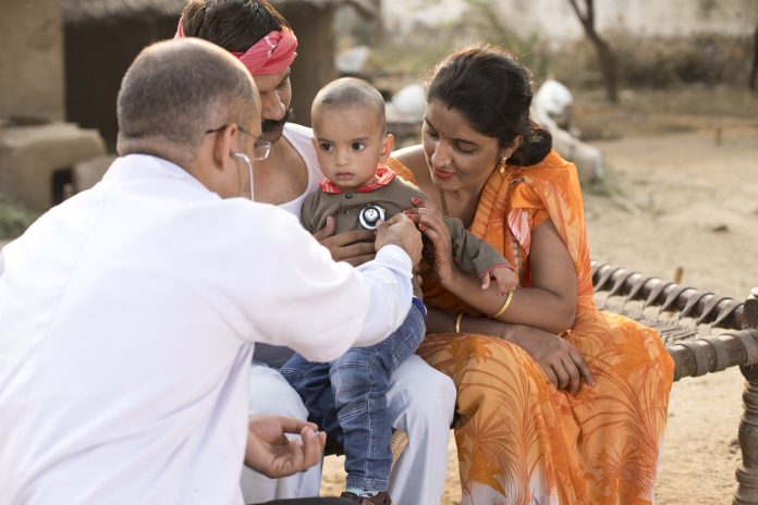 Pediatrician doctor examining ill boy at village