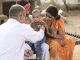 Pediatrician doctor examining ill boy at village