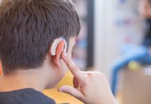 young boy using hearing aid