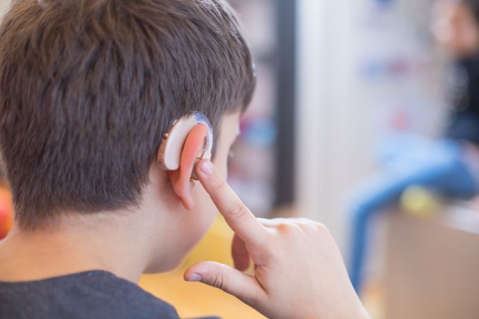 young boy using hearing aid