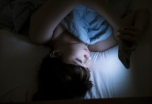 Woman Using Cellphone In Bed At Night