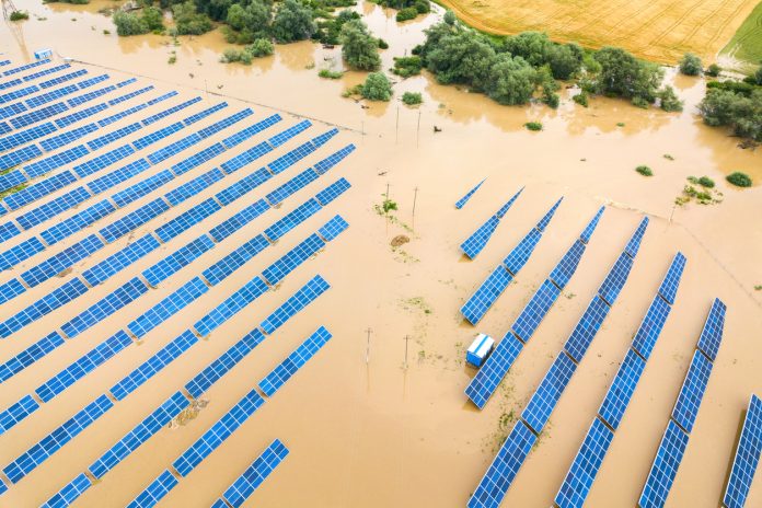 Aerial view of flooded solar power station with dirty river water in rain season.