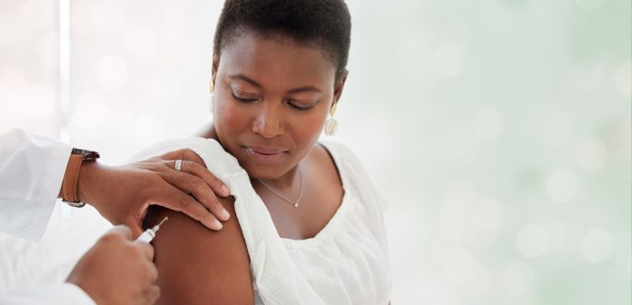 Femme noire, injection de vaccin covid et espace de maquette à l'hôpital avec médecin, infirmière et arrière-plan flou. Patient africain, médecin et maquette médicale pour les soins de santé, le bien-être et le service public