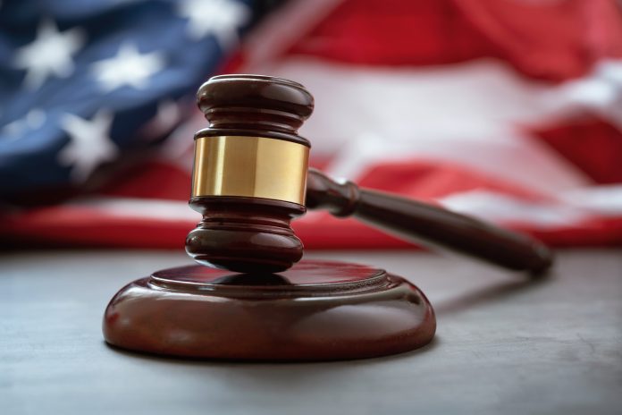 Close up of wooden judge gavel over the american flag with copy space