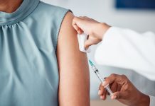 Hands, medical and doctor with patient for vaccine in a clinic for healthcare treatment for prevention. Closeup of a nurse doing a vaccination injection with a needle syringe in a medicare hospital.