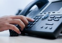 c up employee man hand point to press button number on telephone office desk for contact customer or colleagues in company .hotline employee concept