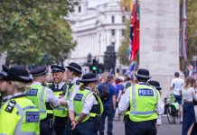 Happy laughing group of metropolitan police officers patrols the crowds of tourists in Whitehall in Westminster, London, UK