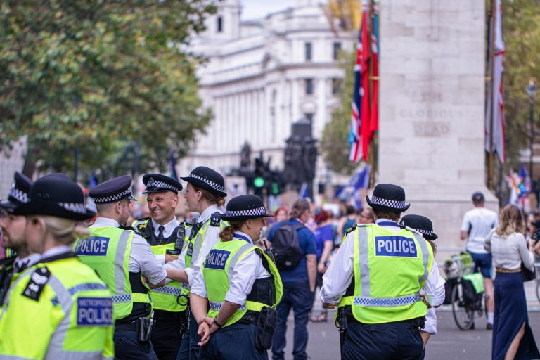 Happy laughing group of metropolitan police officers patrols the crowds of tourists in Whitehall in Westminster, London, UK