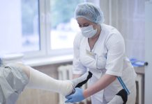 The nurse is bandaging the patient's leg. Leg fracture. Man in a surgical hospital for bandaging.