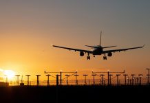 Landing passenger plane during sunset.