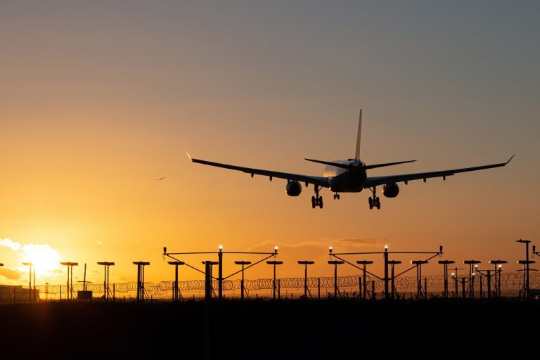 Landing passenger plane during sunset.