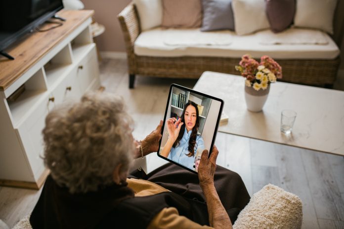 Young medical practitioner on a video call with her senior patient