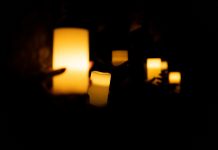 Female hands holding candles in protest watch agains feminicides