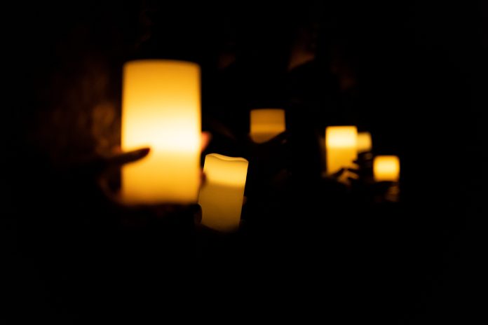 Female hands holding candles in protest watch agains feminicides