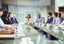 Business people having meeting in in conference room, smiling and discussing