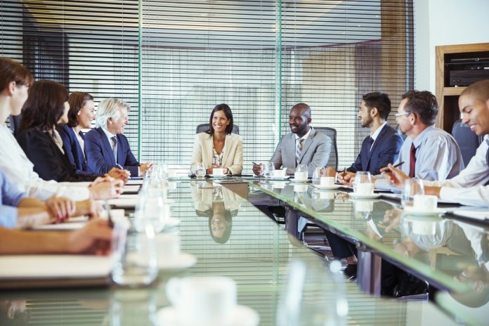 Business people having meeting in in conference room, smiling and discussing