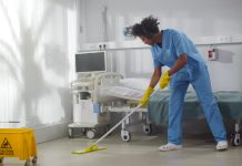 Afro-american,Male,Janitor,In,Headphones,Washing,Floor,In,Hospital,Ward.