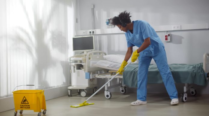 Afro-american,Male,Janitor,In,Headphones,Washing,Floor,In,Hospital,Ward.