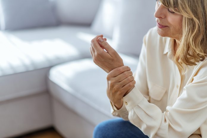 Senior woman suffering from pain in hand at home