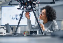 Concentrated Black Female Engineer Writing Code. Developing Software for Modern Drone Control in the Research Center Laboratory. Technological Breakthrough in Flight Industries Concept.