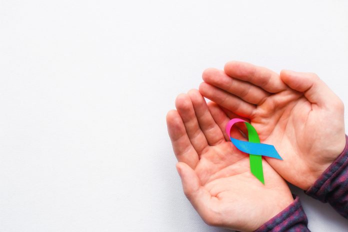 man holding a symbol of World AIDS Day