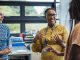 A shot of a mid-adult secondary school teacher talking with her sixth form students in class, they are wearing casual clothing and discussing what they learned in class, in a school in Gateshead, England.