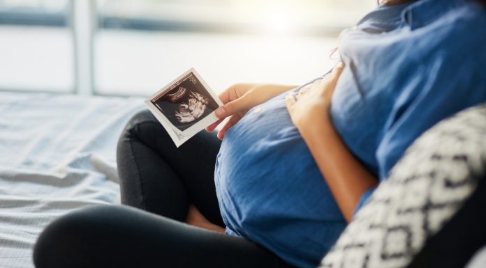 Closeup shot of an unrecognizable pregnant woman holding an ultrasound scan