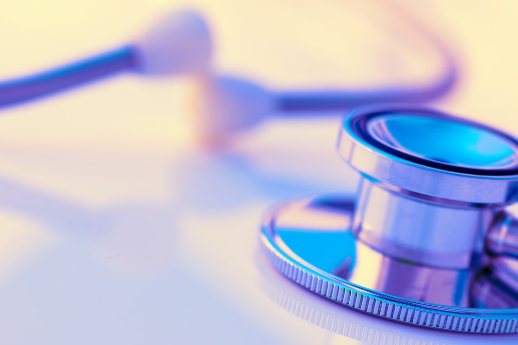 Close-up of a stethoscope on a desk. Shallow depth of field, space for copy. Toned image.