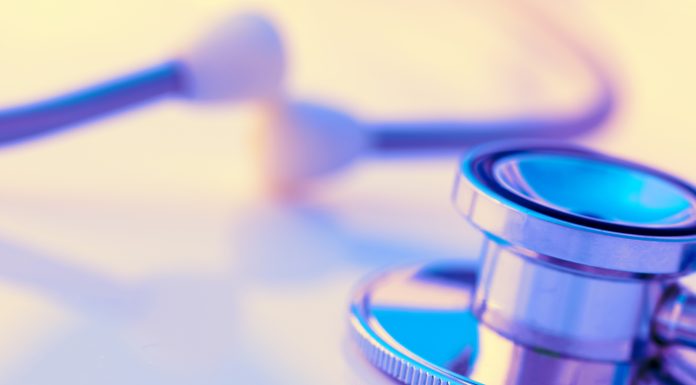 Close-up of a stethoscope on a desk. Shallow depth of field, space for copy. Toned image.