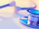 Close-up of a stethoscope on a desk. Shallow depth of field, space for copy. Toned image.