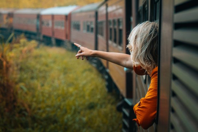 A woman enjoys a train ride in Sri Lanka