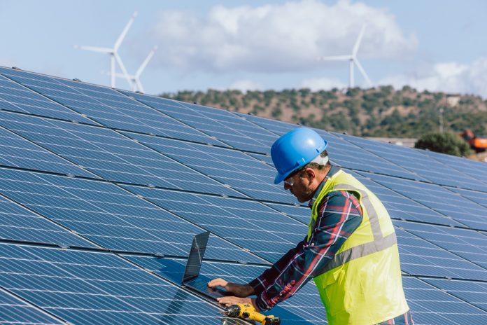 Engineer Man at Work: Managing and Optimizing Efficiency at the Solar Energy Photovoltaic Farm with Laptop Technology